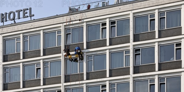 Two male glass cleaners abseiling down the hotel façade to clean windows, aletto Hotel Kudamm,