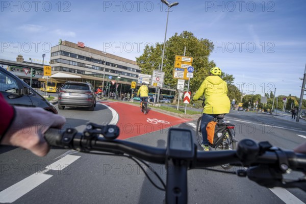 Riding a bike in a bike lane, marked in red to attract the attention of motorists, between 2 lanes,