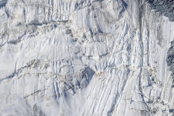 Intricate patterns of ice and rock are showcased in this stunning glacial landscape, revealing the