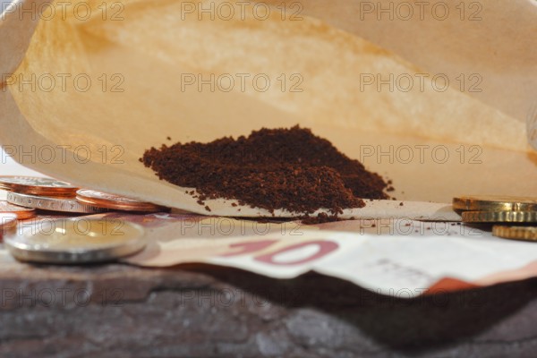 Ground coffee in a filter bag with coins and a ten euro note in front of it, North