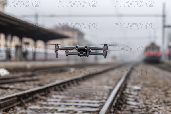 Ein Fernpilot steuert sein Quadrocopter, Drohne illegal über Bahnhofsgelände, Bahngelände,