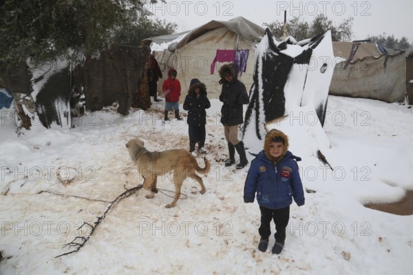 Displaced Syrian families and children living in refugee camps during harsh winter conditions,
