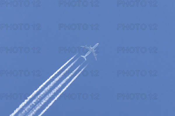 Airbus A340-300 jet aircraft of Lufthansa airlines in flight in a blue sky with vapour trails or