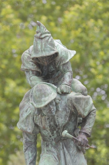 Sculpture Huckup monument by Carl Röder 1905, carrying figures on the back, modern art, bronze