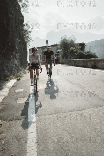 Woman and man riding racing bikes in Italy on Lake Garda