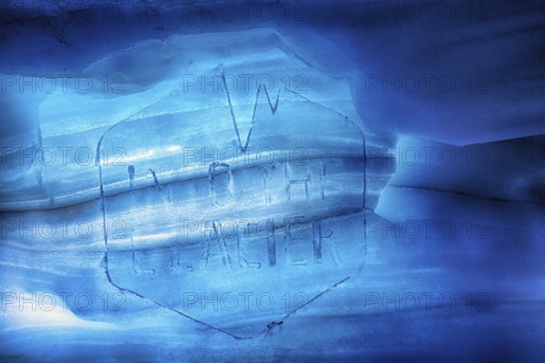 Faded logo with inscription, engraving in melting ice, Into the Glacier, ice tunnel, glacier cave,