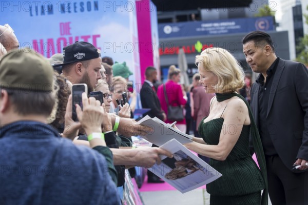 Pamela Anderson signs autographs in front of the film premiere of The Naked Gun at UCI Luxe East