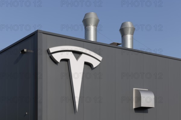 Tesla, logo on modern workshop building, figurative mark without lettering, US car manufacturer for