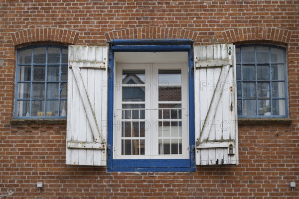 Window with shutters, brick façade, warehouse building, old town centre, Husum, North Frisia,