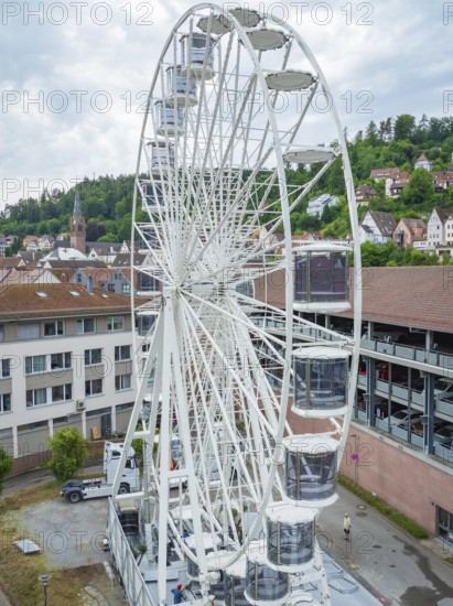 A large Ferris wheel in an urban environment with a cloudy sky, Ferris wheel construction for the