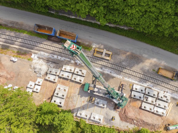 Industrial structure from the air with railway tracks and concrete blocks adjacent to a road,