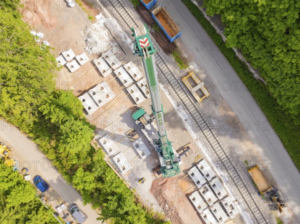 A large crane on a construction site next to rails and building materials, construction of the