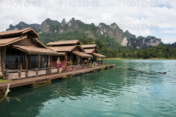 Floating houses on lake with jungle and rainforest and steep mountains, Cheow Lan Lake, Khao Sok