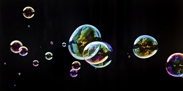 Iridescent soap bubbles in the colours of the rainbow against a black background, Recklinghausen,