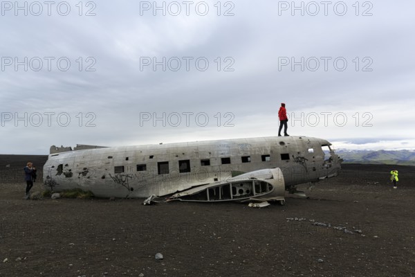 Tourist on aircraft wreckage, US Navy Douglas DC-3 transport plane, Sander, volcanic landscape,