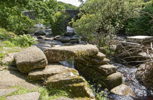 Remains of an old stone bridge and the new bridge on the East Dart River in Dartmoor National Park.