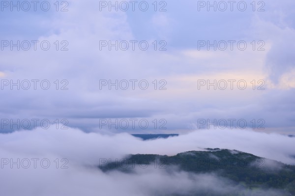 Dense fog over a hilly landscape with colourful morning sky and clouds, summer, Rhine bend Boppard,
