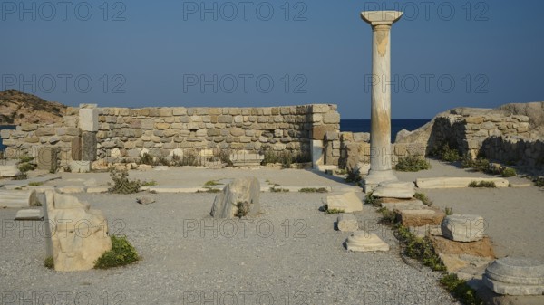 Ancient site with a single stone column and ruins, near the sea, Agios Stefanos Beach, Agios