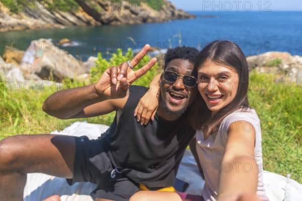 Young tourists enjoying a sunny day by the sea, sharing joyful moments while taking selfies and