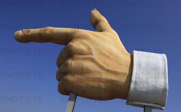 Plastic sculpture of a human hand with an outstretched index finger to indicate a direction