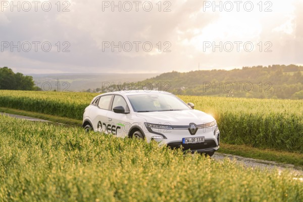 Renault vehicle standing in the middle of a field at sunset in the background, Deer E- CarSharing,