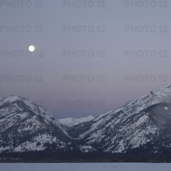 Moonset... Rocky Mountains (Wyoming, USA), full moon in ice-cold night over the Grand Teton Range