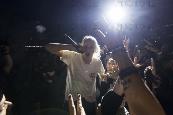Emily Armstrong, lead singer of Linkin Park in the photo pit between the audience live on From Zero