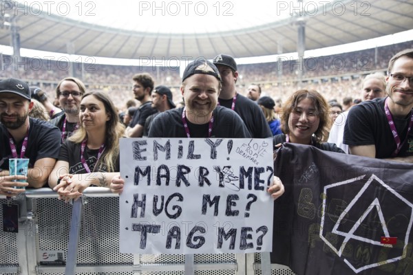 A fan holds a poster with the words Emily! Marry me? Hug me? Tag me? (Emily! Marry me? Hug me? Link