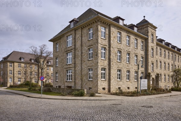Tax office, sandstone building, bare wintry trees, diffuse light, slightly sunny, cloudy, street