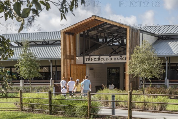 Family entering the Tri-Circle-D Ranch horse stables in the Fort Wilderness Campground and Resort