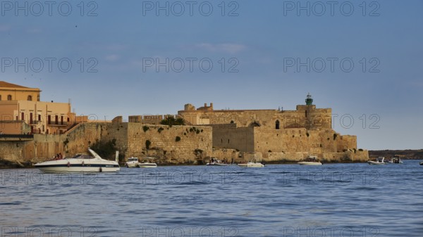 Castello Maniace, Maniace sea fortress, old defence defence tower by the sea with passing boats