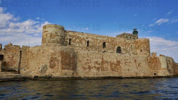 Castello Maniace, Maniace sea fortress, medieval castle with lighthouse by the sea under a blue