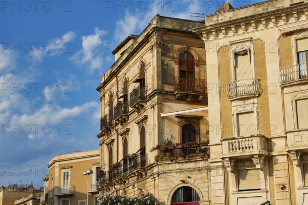 Close-up view of historic buildings with balconies and windows under blue sky, Ortigia Island,