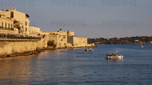 Castello Maniace, sea fortress Maniace, coastal town in the evening light with boats and historic