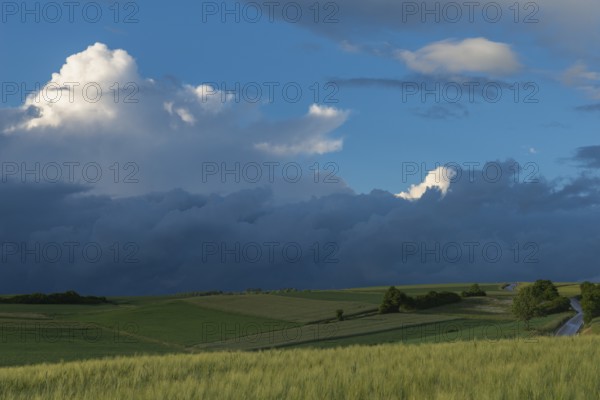 Dramatic cloudy sky with approaching storm and last rays of sunshine, Frankenhain, dark cloud wall,