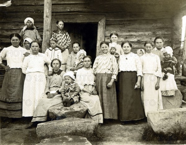 Large family in the countryside, 1920s, Group of woman and children in front of a wooden house,