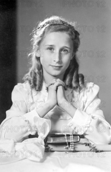 Praying girl, 1930s, A young girl in nostalgic clothing, dreamy and elegant, looks at the viewer,