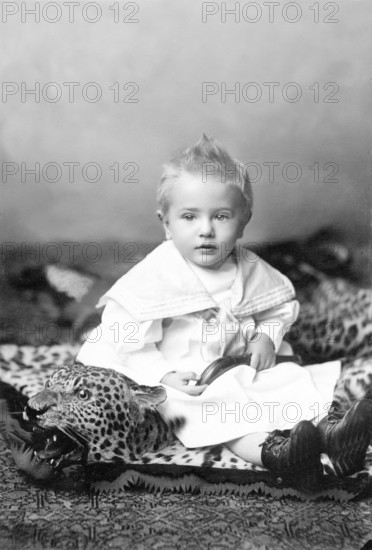 Little boy sitting on a leopard skin, 1910s, A little boy in a traditional outfit sits on a toy