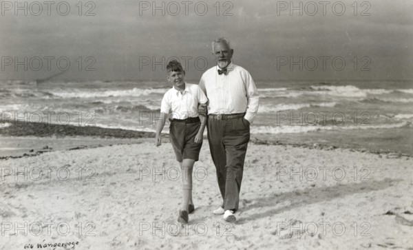 Grandpa and grandson on the beach of Wangerooge, 1930s, Elderly man and boy walking along the