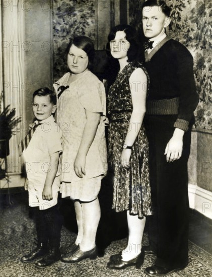 Family photo set up according to size, 1920s, Four people posing standing for a family portrait,
