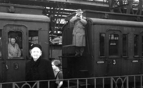 Train station hall photographer, 1930s, people on a platform, a man photographed from a carriage,