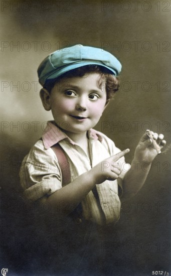 Little boy with a cigarette, 1930s, A boy in a colourful cap and shirt playfully holds a cigar and