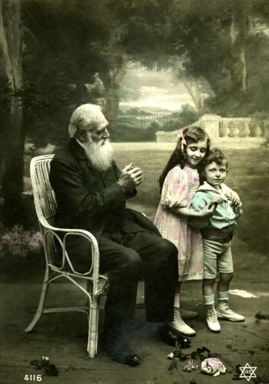 Grandpa with 2 children, 1910, An elderly man sits in the garden with two children standing happily
