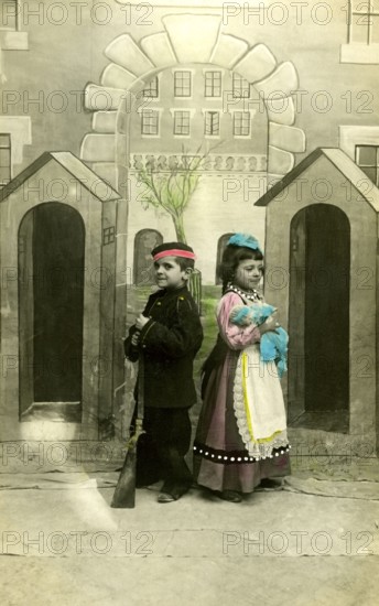 2 children dressed up, 1920, Two children in costumes with toy gun, in front of a painted scenery,