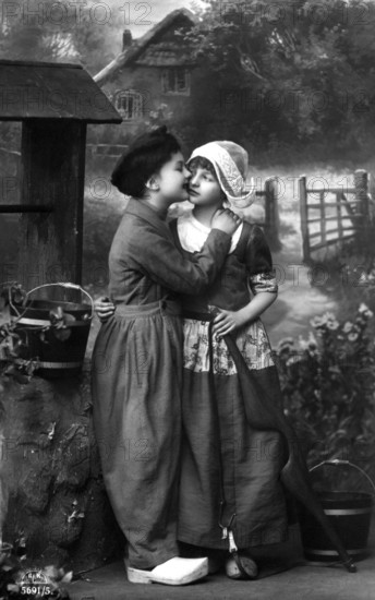 Boy kissing girl, 1920, Two children in old-fashioned clothes in front of a house in the country,