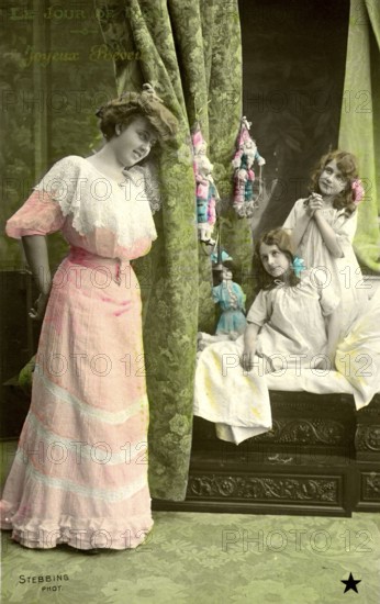 Mother with 2 girls, 1910, Three woman in Victorian dresses posing in front of green curtains,