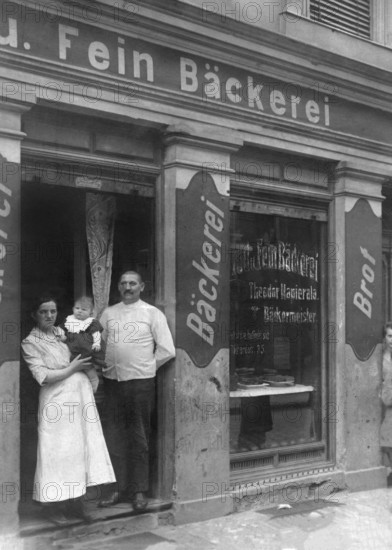 Couple in front of bakery, ca. 1915, Family posing in front of their traditional bakery with