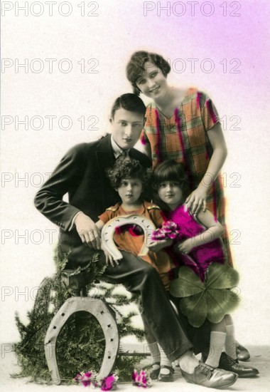 Horseshoe lucky family, 1910, A family poses together with lucky symbols such as horseshoe and