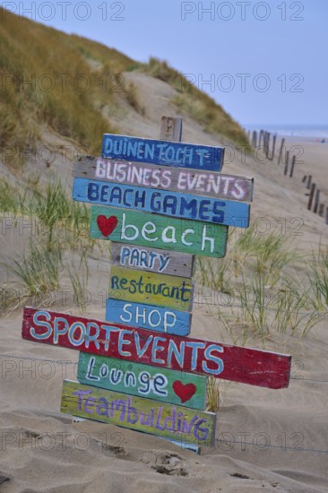 Wooden signs with colourful lettering stand in the dune sand on the beach, beach section 27,