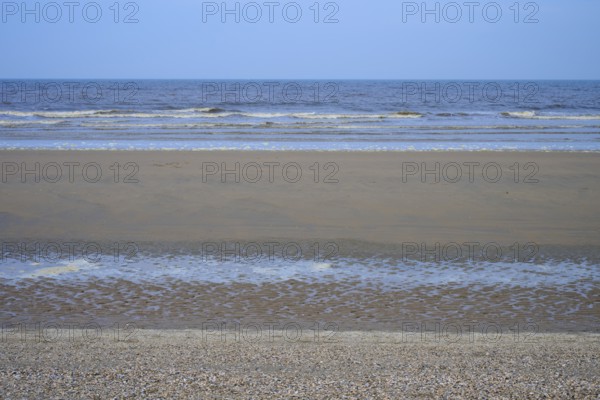 View of a wide sandy beach with gentle waves under a clear sky, beach section 27, Noordwijk, North